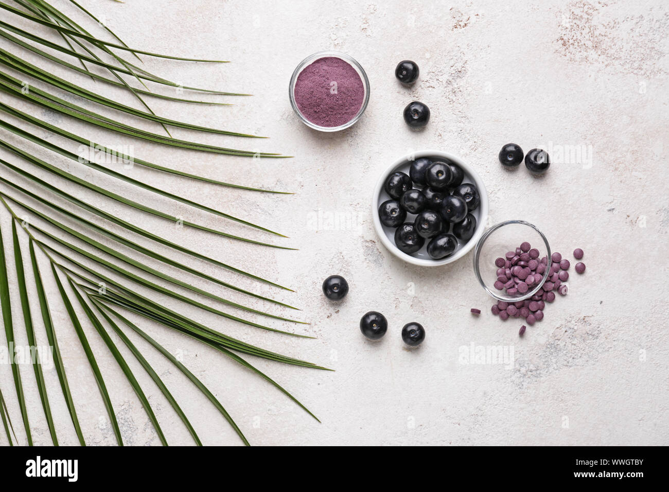 Acai berries with powder and tablets on white background Stock Photo