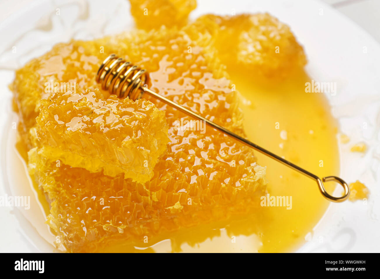 Fresh honey combs and dipper on plate, closeup Stock Photo - Alamy