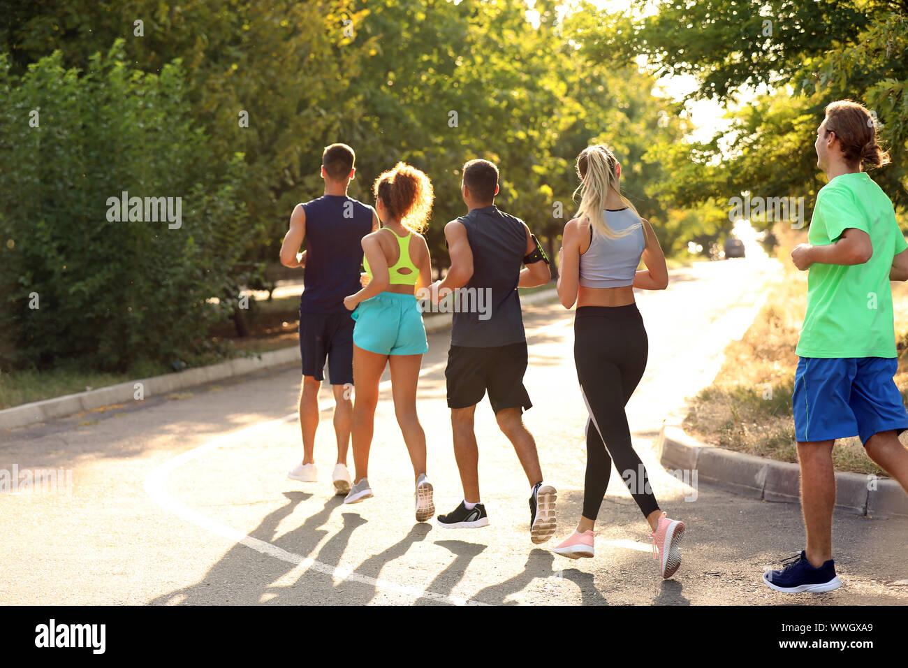 Group of sporty young people running outdoors Stock Photo - Alamy