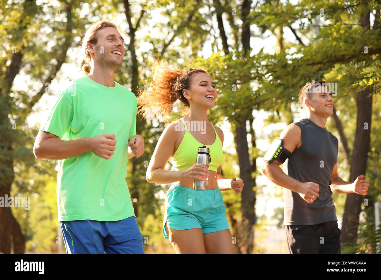 Group of sporty young people running outdoors Stock Photo - Alamy