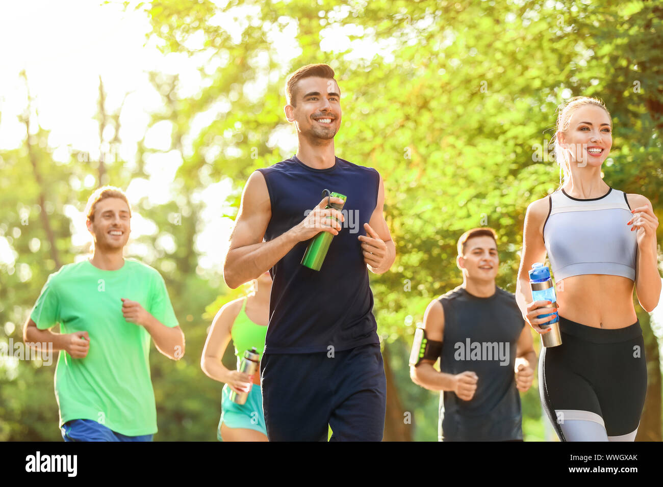Group of sporty young people running outdoors Stock Photo - Alamy