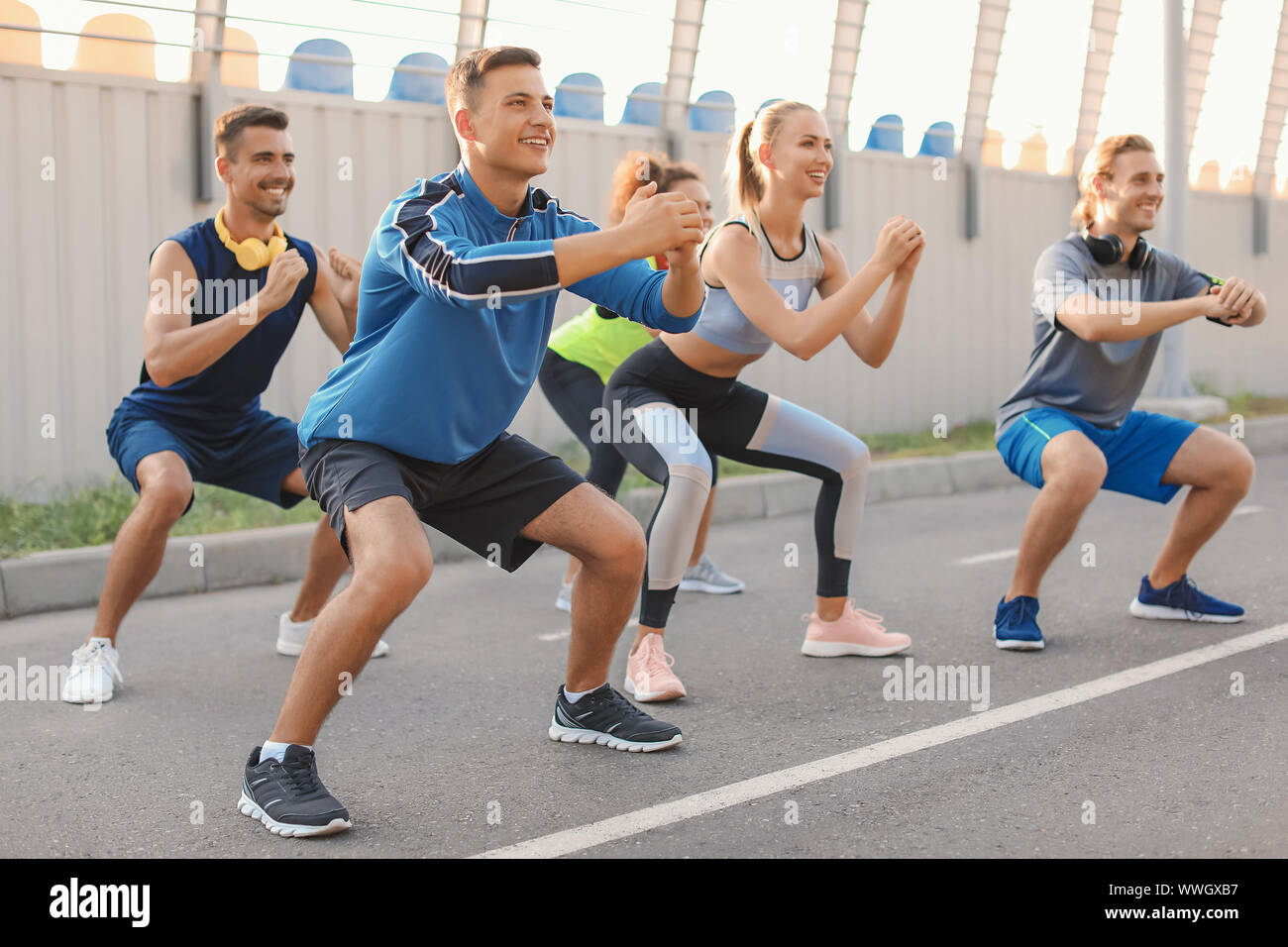 Group of sporty young people training outdoors Stock Photo - Alamy