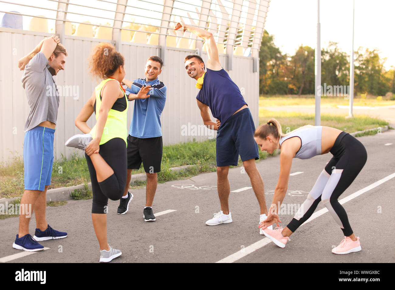 Group of sporty young people training outdoors Stock Photo - Alamy