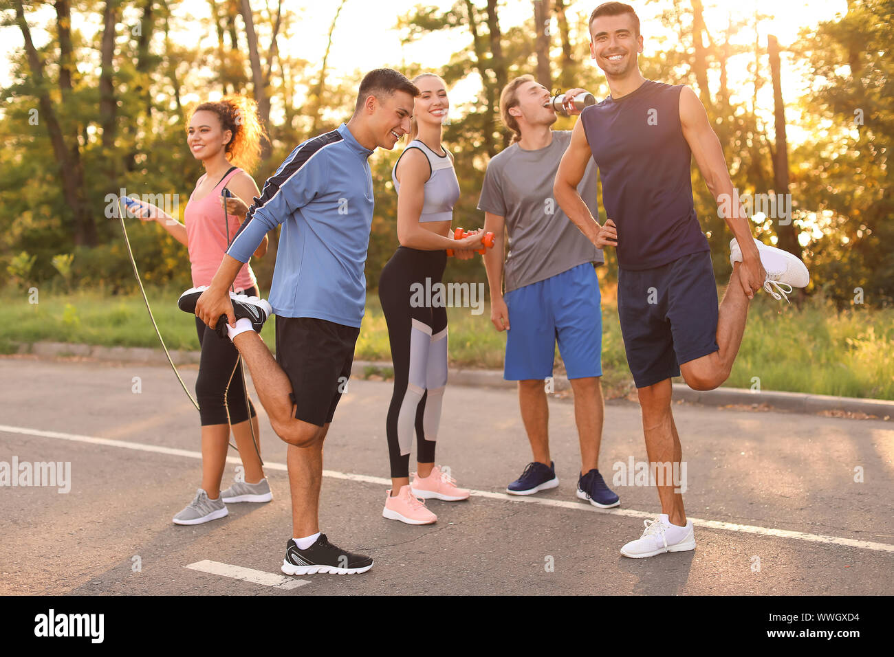 Group of sporty young people training outdoors Stock Photo - Alamy