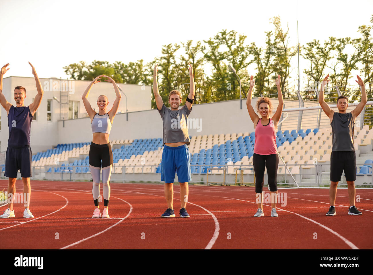 Group of sporty young people training at the stadium Stock Photo - Alamy