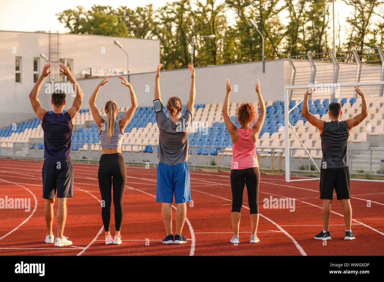 Group of sporty young people training at the stadium Stock Photo - Alamy