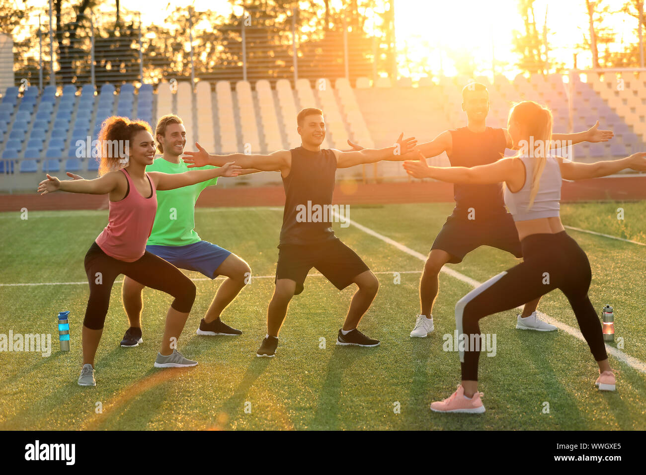 Group of sporty young people training at the stadium Stock Photo - Alamy