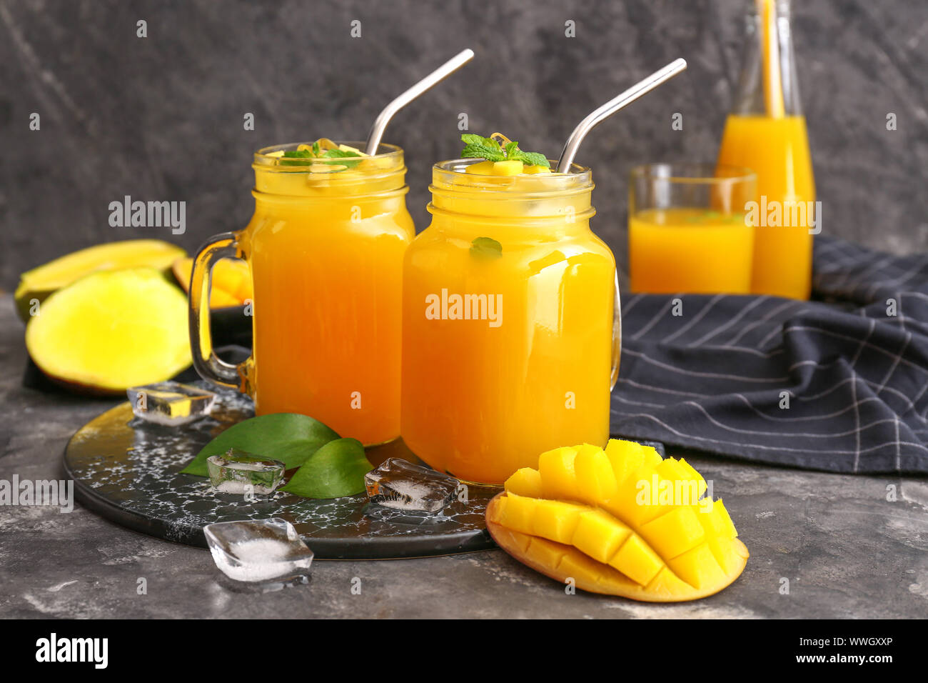 Mason jars of fresh mango juice on table Stock Photo - Alamy