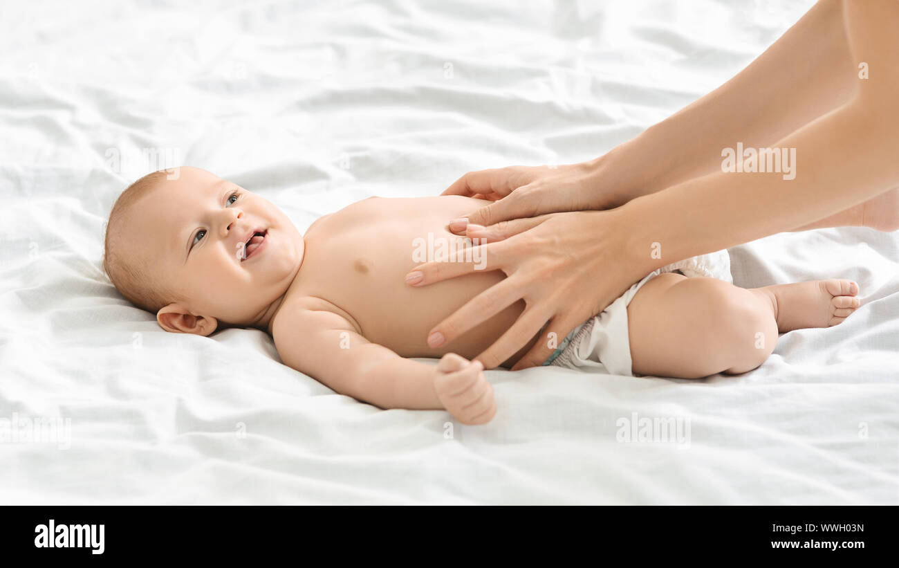 Colucs Mother massaging tummy of newborn baby to prevent colics Stock Photo ...