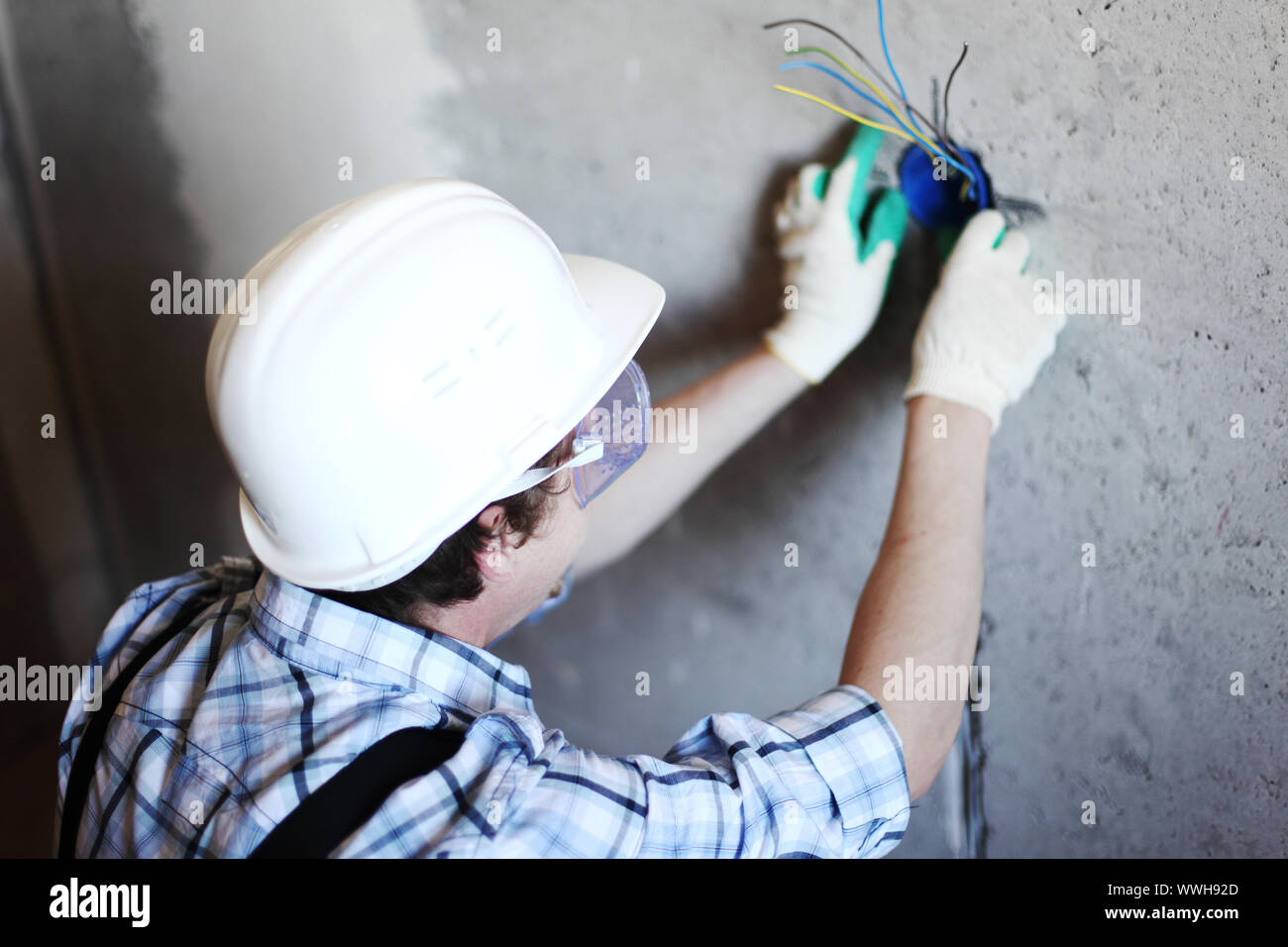 worker puts the wires in the wall Stock Photo Alamy
