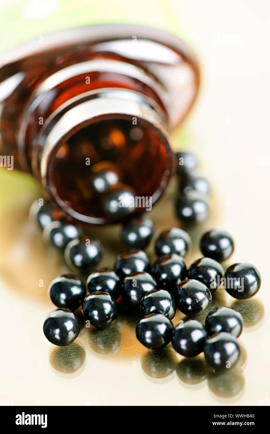 Traditional chinese herbal medicine pills spilling from bottle Stock
