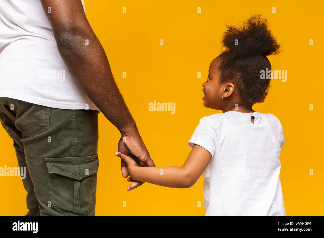African father and little daughter holding hands Stock Photo - Alamy