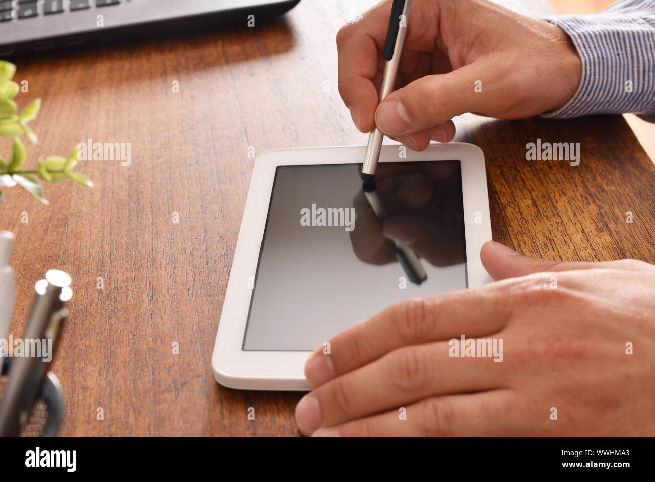 Businessman using white tablet with black screen in office. Horizontal composition. Top view Stock Photo