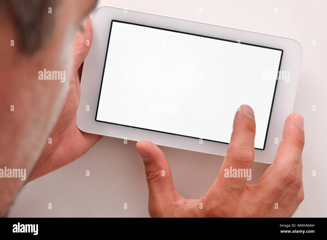 Man using white tablet with white screen on wood table close up. Horizontal composition. Top view Stock Photo