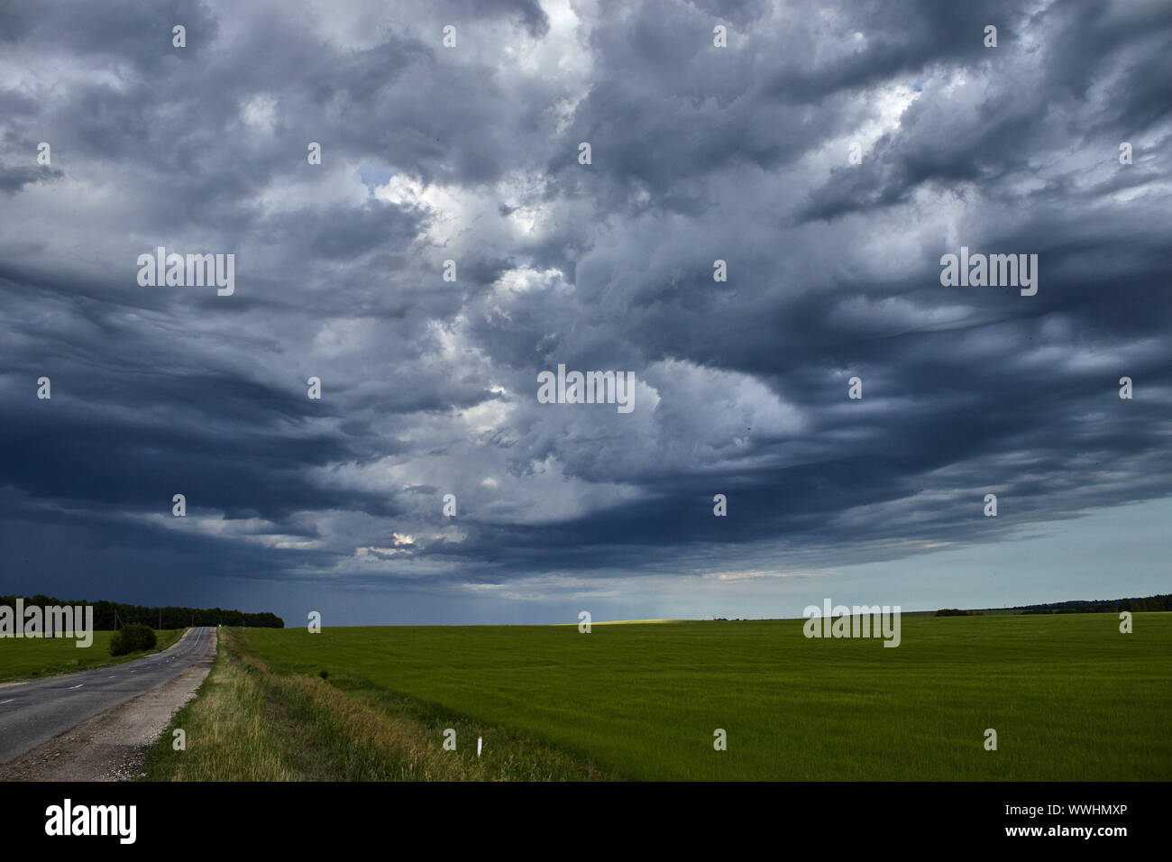 country road along the field under heavy clouds Stock Photo - Alamy