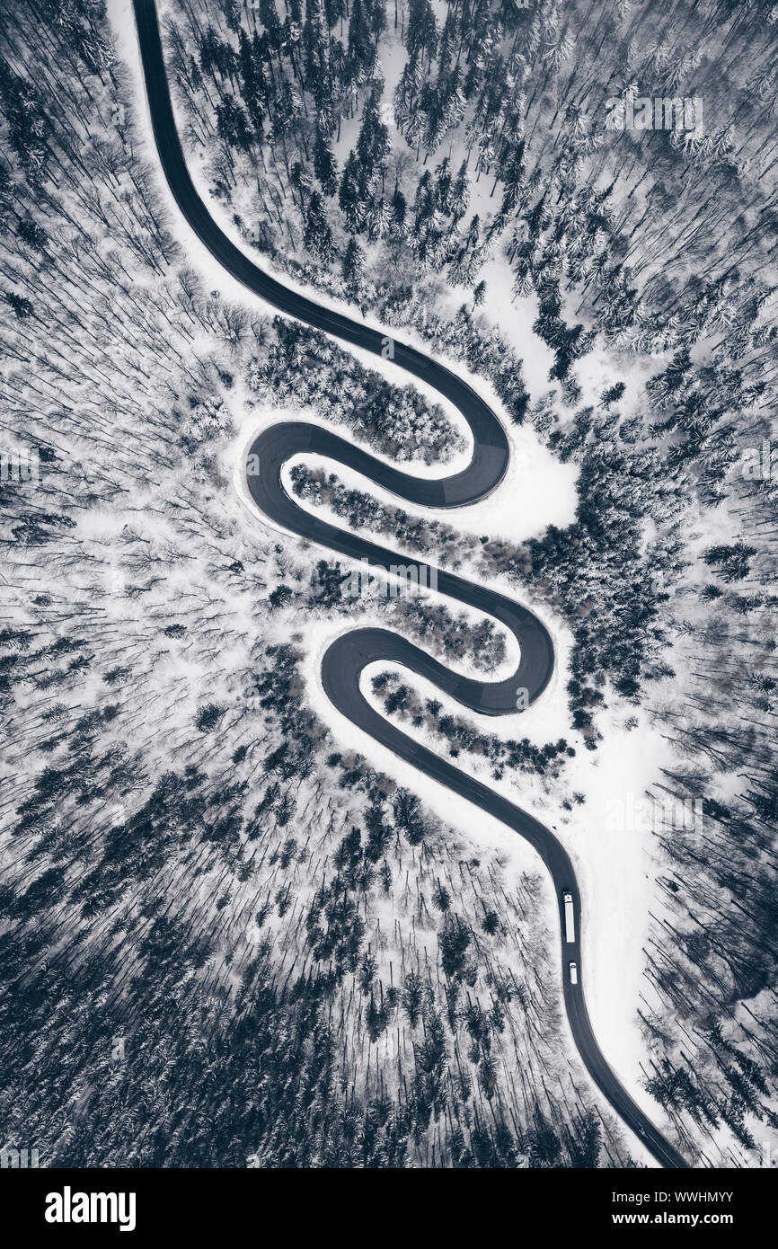 Top down view of a road in the middle of the forest in winter season Stock Photo