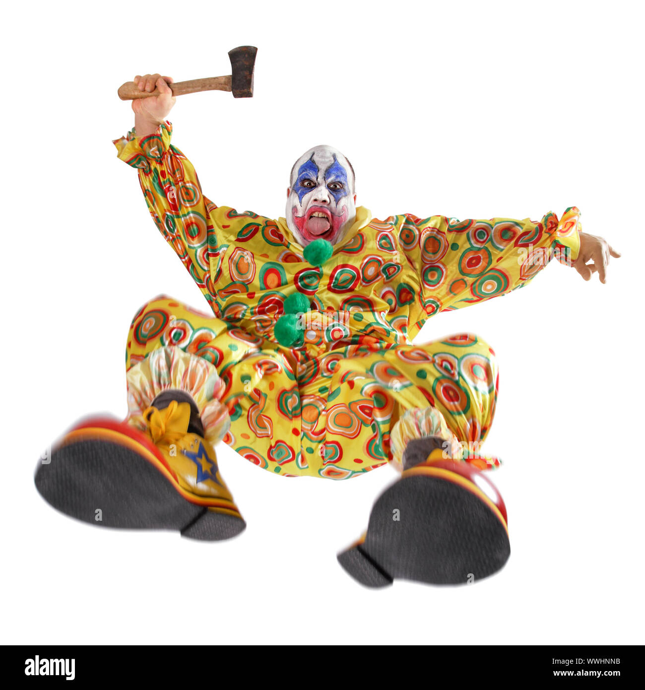 A nasty evil clown, angry, jumping, and about to hack you to bits.  Motion blur on the knees and shoes. Stock Photo