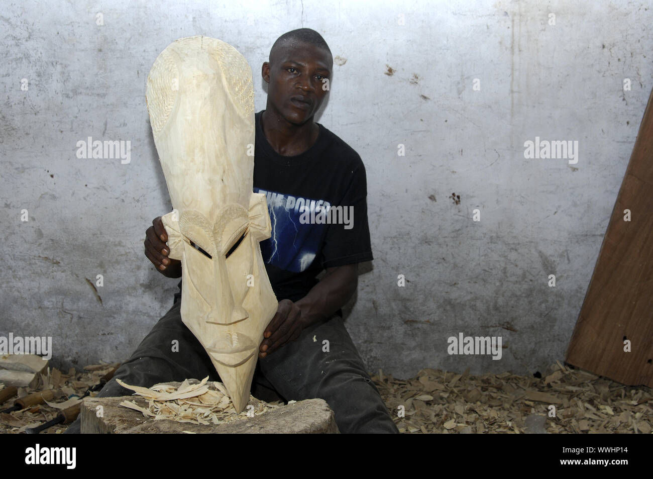 Wood carver shows raw wooden mask, Aburi, Ghana Stock Photo
