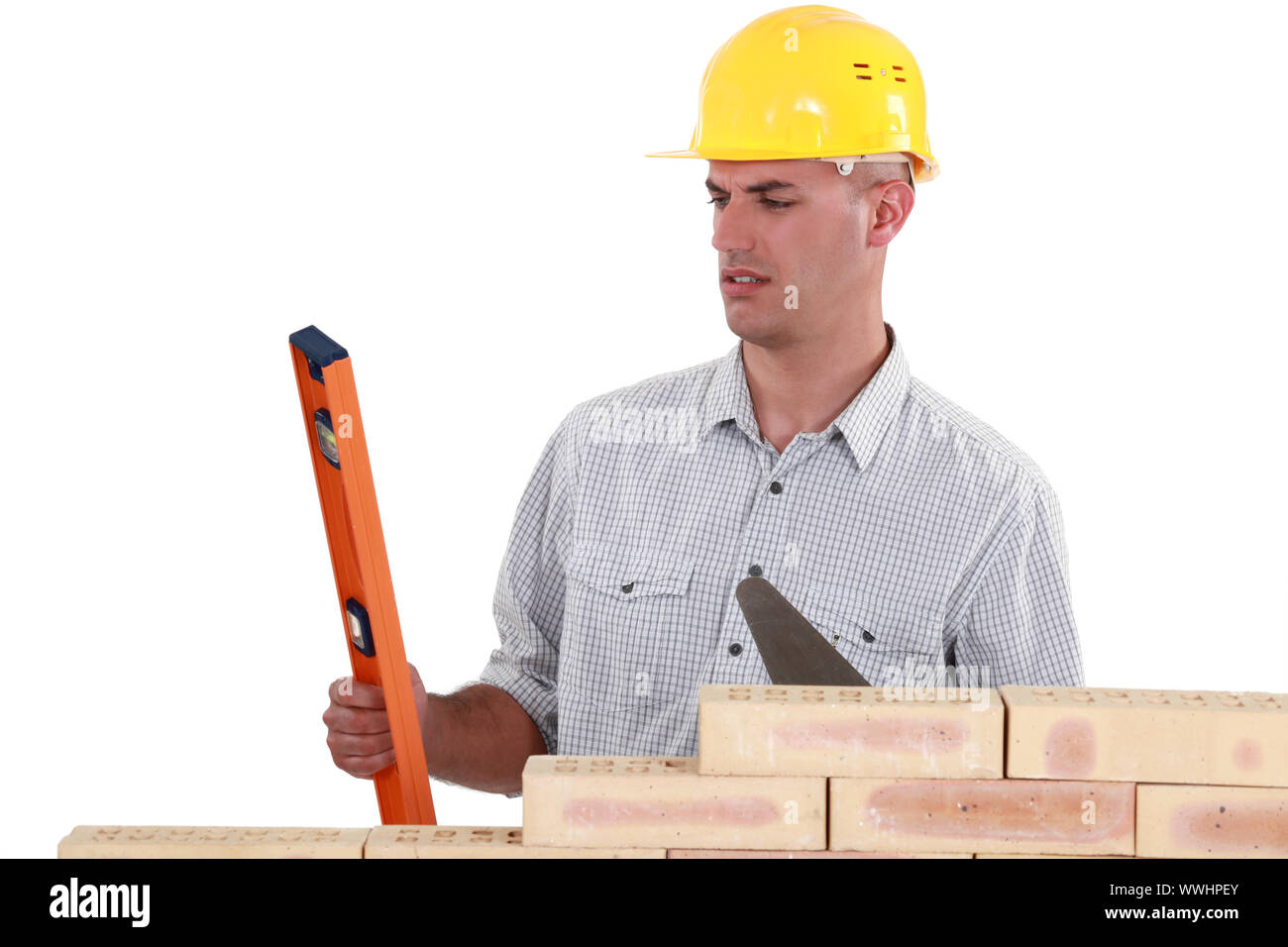 mason holding a level and a trowel Stock Photo