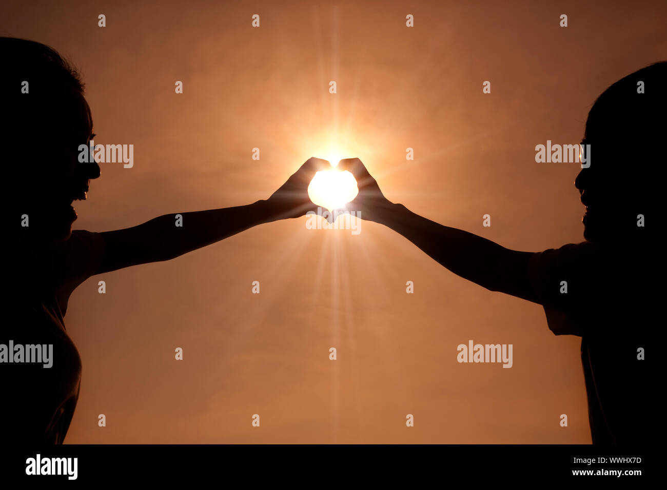 happy young couple making heart shape with hands at sunset Stock Photo ...