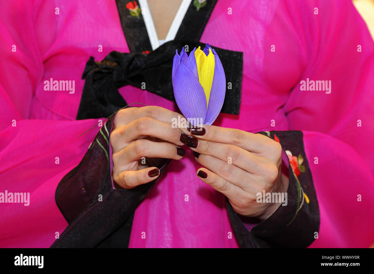 Woman folds a lotus blossom of paper Stock Photo