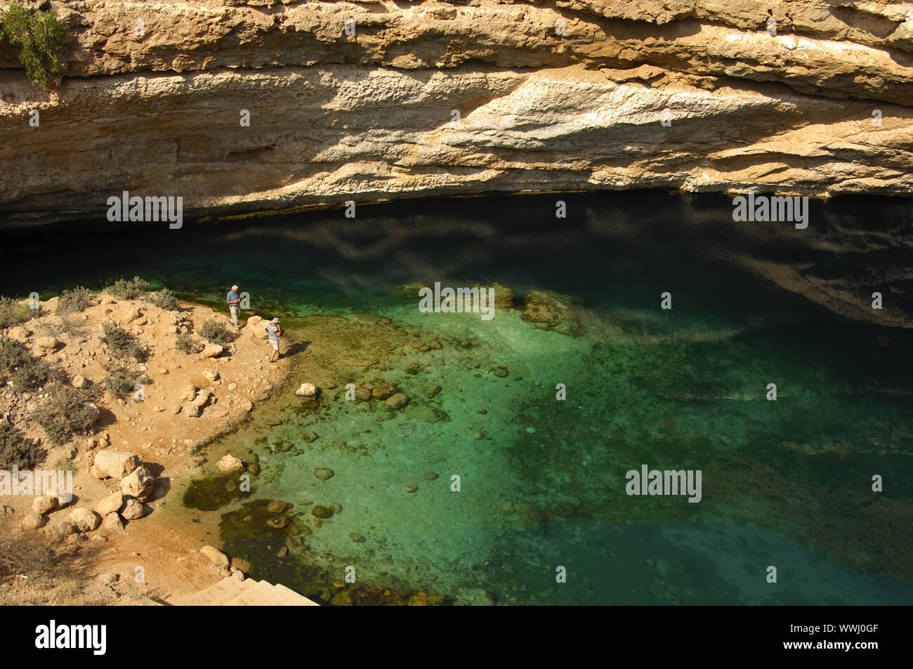 Turquoise water at the bottom of a limestone crater Stock Photo