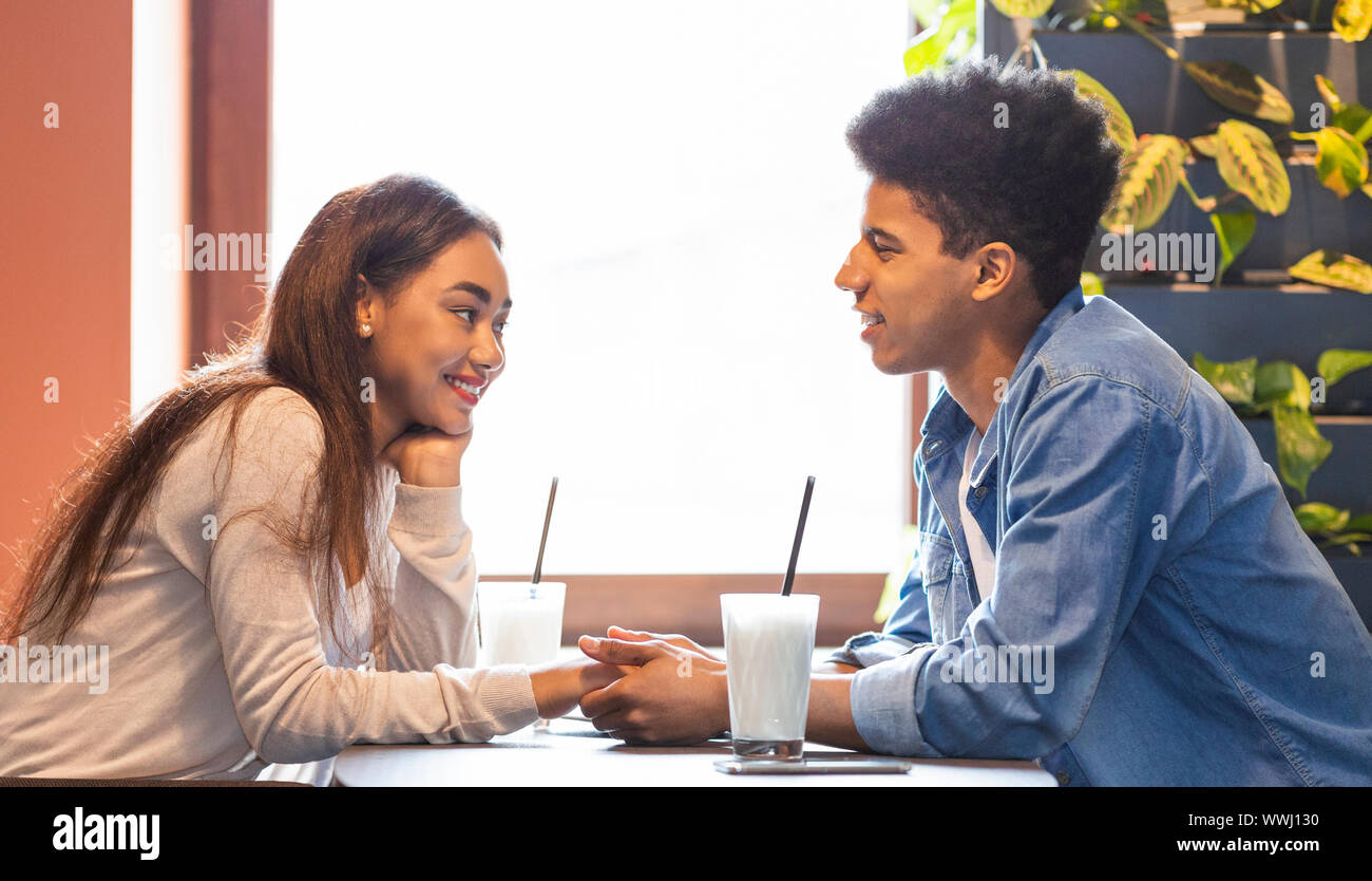 Young Couple In Love Holding Hands, Having Conversation Stock Photo - Alamy