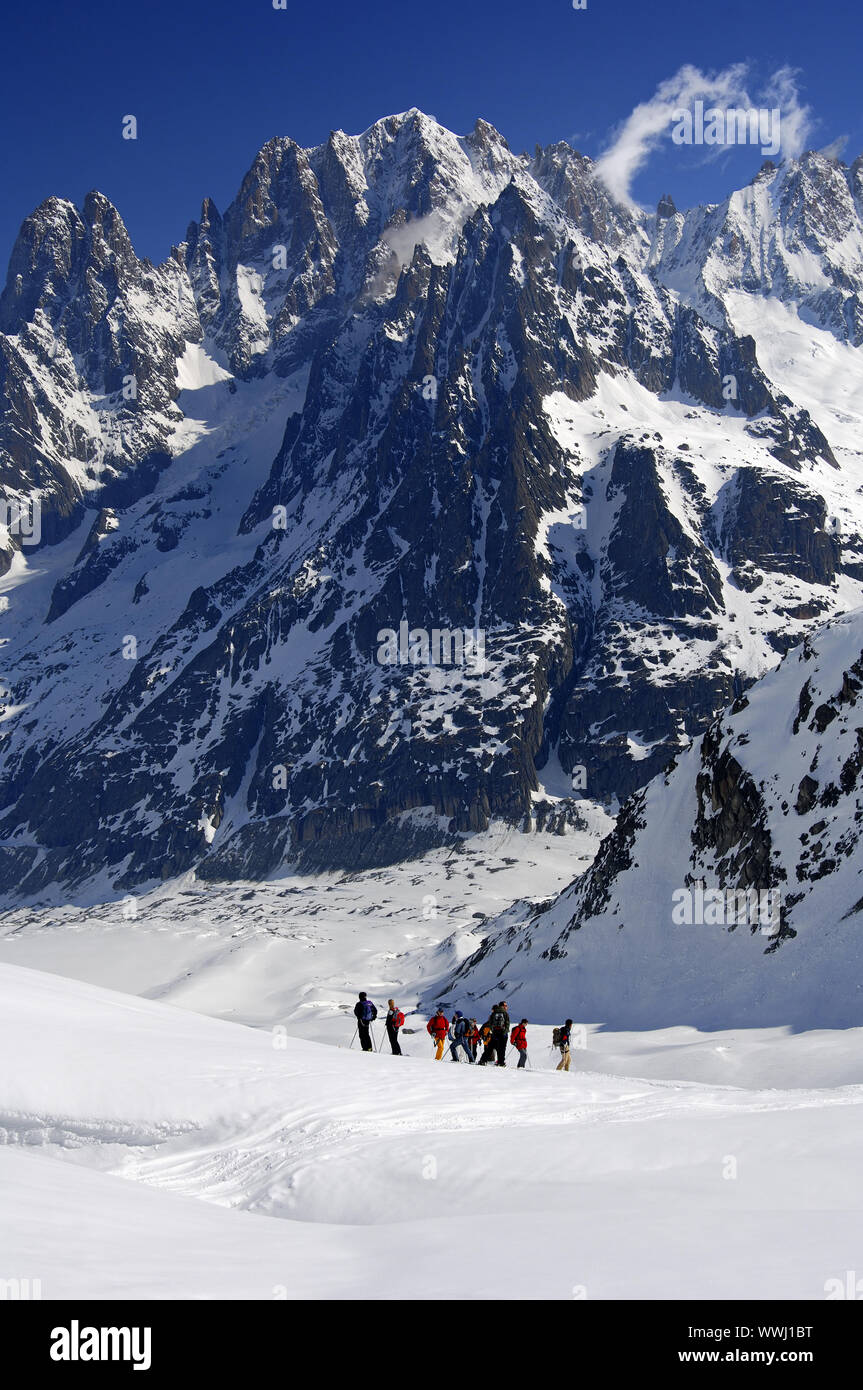 Touring skiers on the Mer de Glace glacier in front of Aiguille Verte Stock Photo