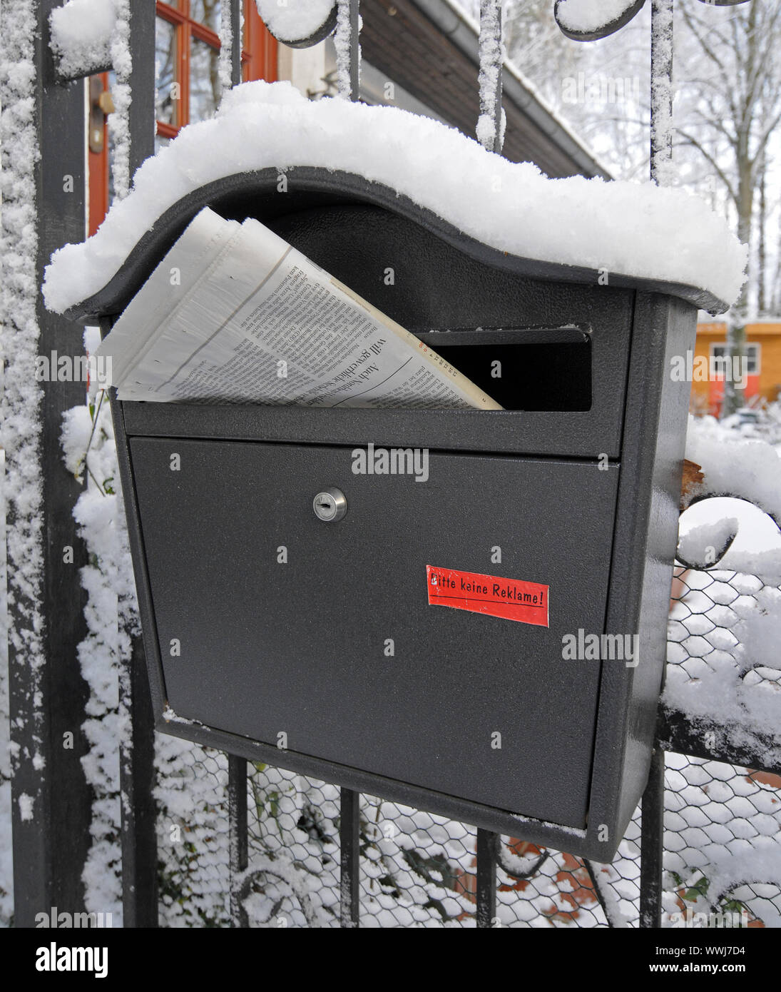 snow-covered letterbox with the Sunday newspaper Stock Photo