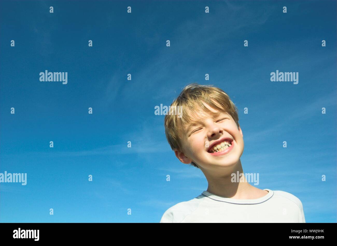 Happy boy on sky background Stock Photo - Alamy