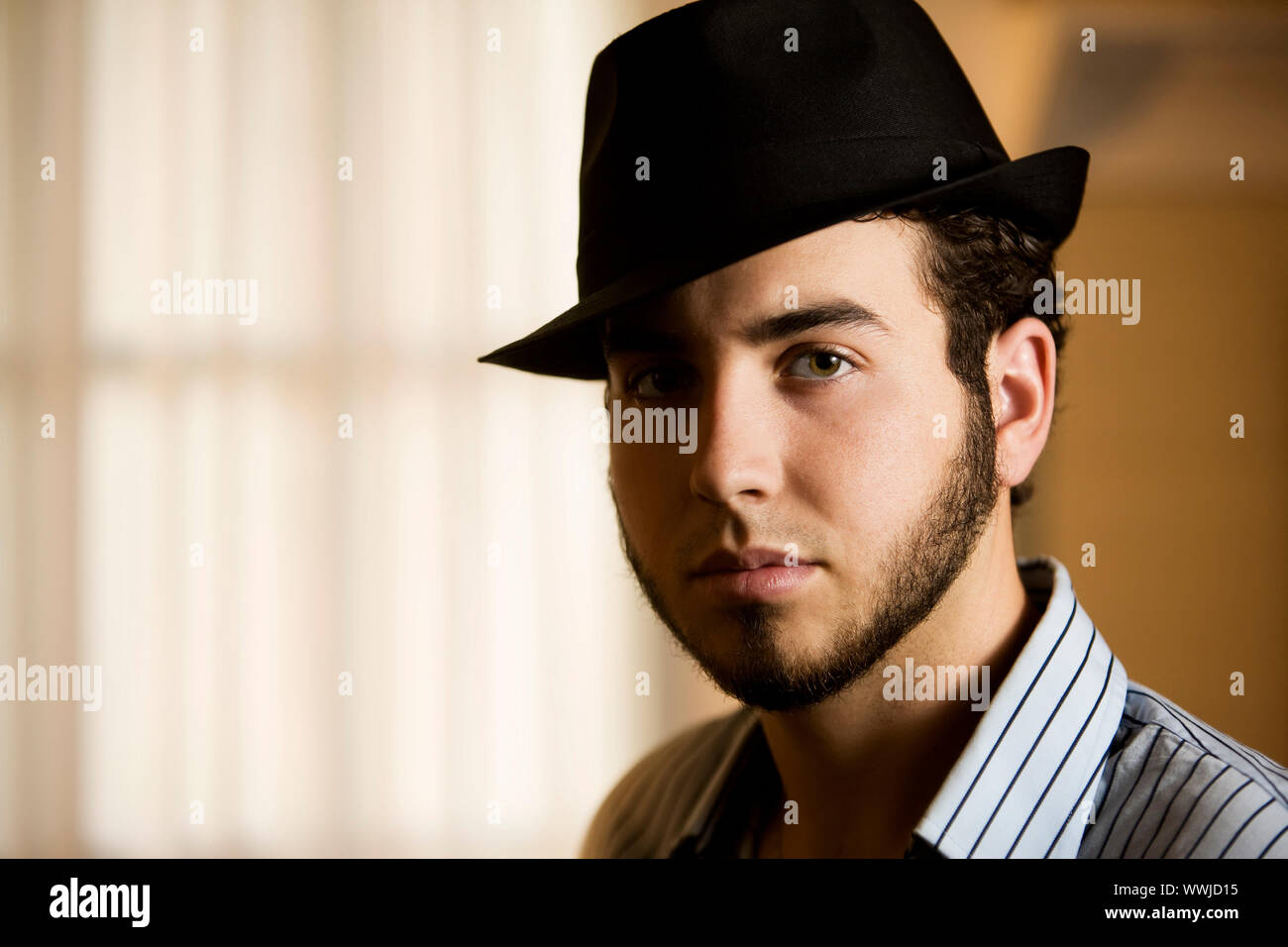 Handsome Young Man Indoors Wearing a Fedora Hat Stock Photo - Alamy