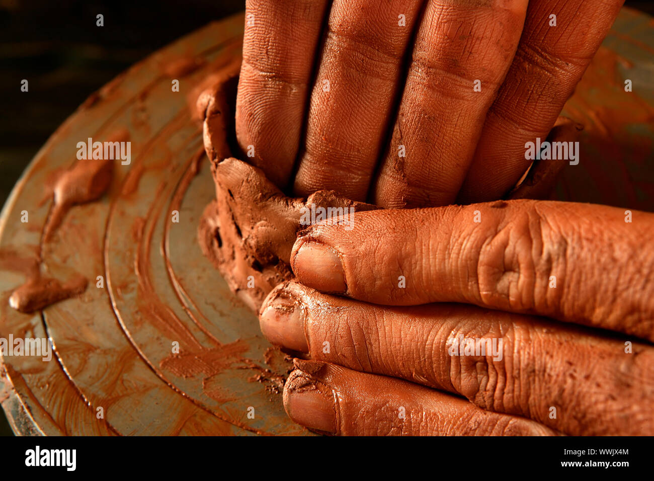 pottery craftmanship red clay potter hands work finger closeup Stock