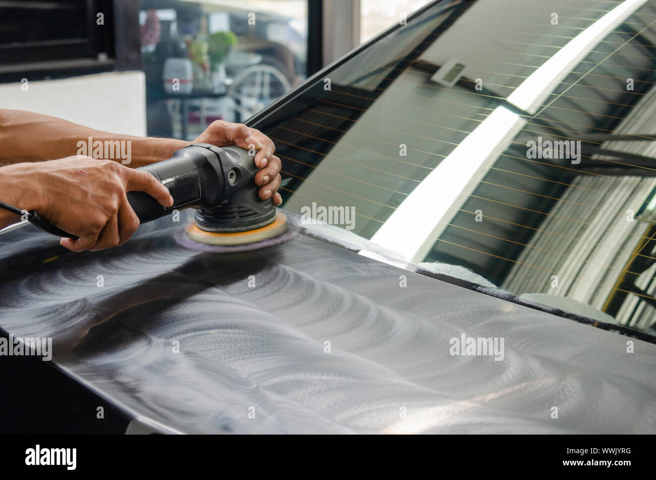 Man working for polishing, coating cars. polishing of the car will help eliminate contaminants on the surface of the car.Waxing the car surface will c Stock Photo