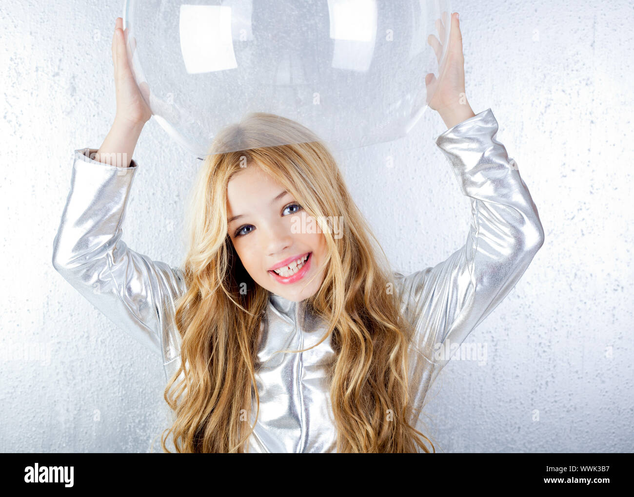 Astronaut futuristic kid girl with silver uniform and glass helmet Stock Photo