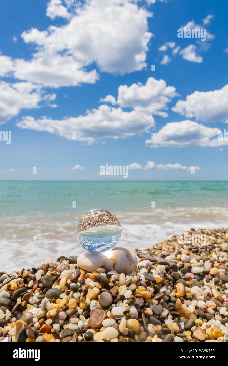 Glass round ball on the beach reflects the sea in summer Stock Photo ...