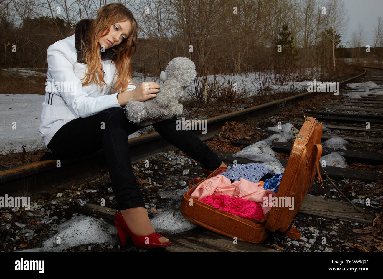 Blonde girl sitting on rail Stock Photo - Alamy