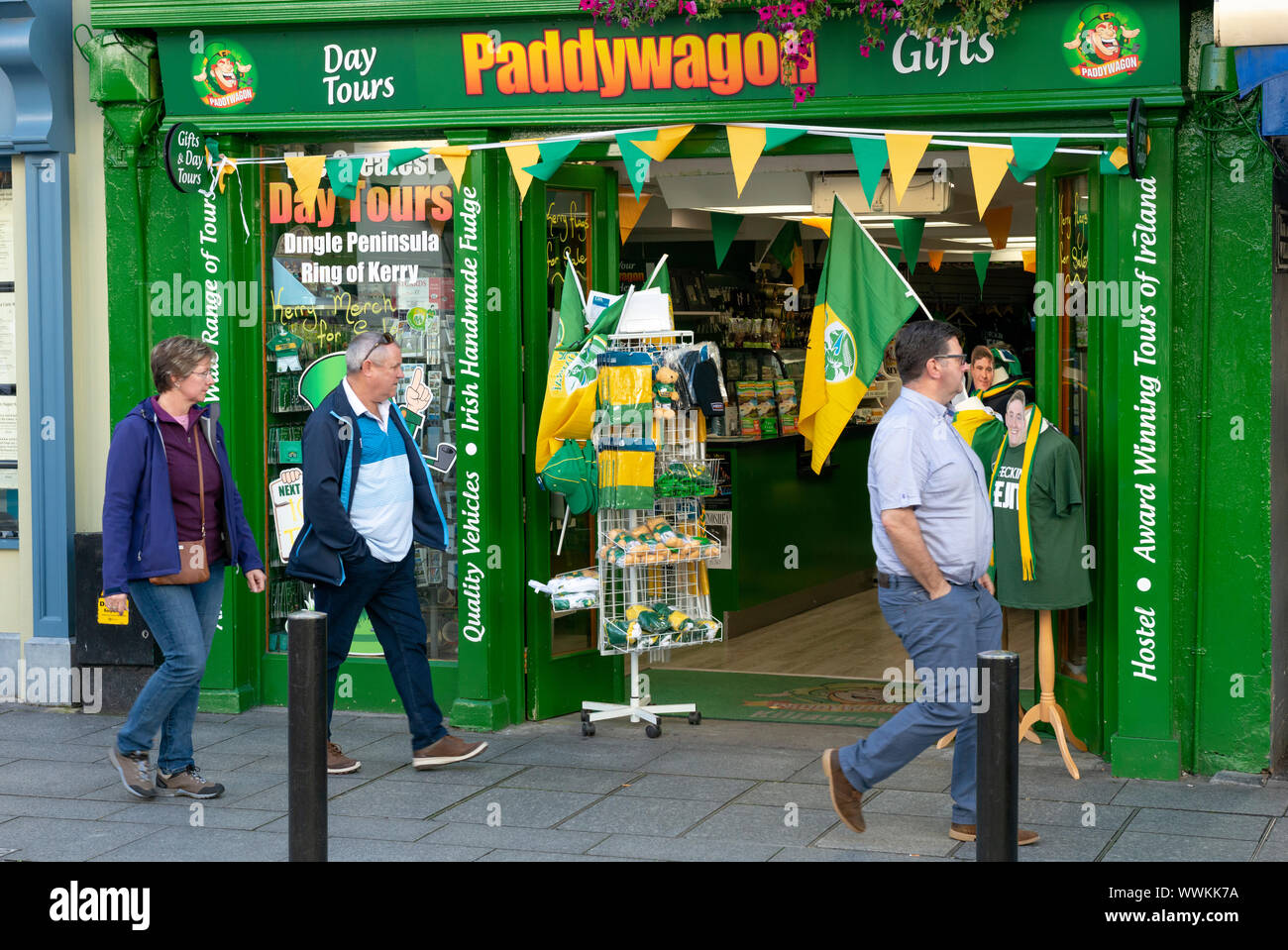 People walking past the Paddywagon day tours and gift gifts shop storefront on Main Street Killarney Ireland Stock Photo