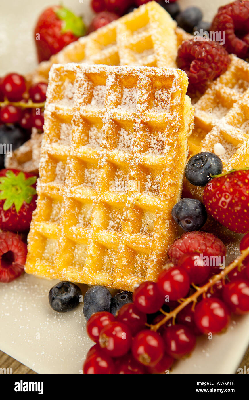 Fresh waffles with icing sugar and berries on one table Stock Photo
