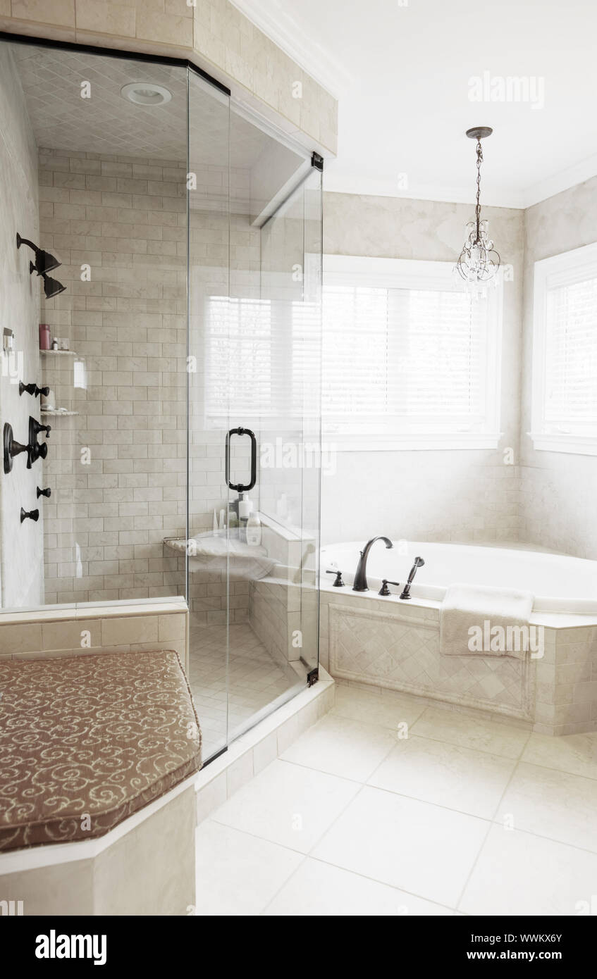 Upscale neutral-toned bathroom with jacuzzi tub and shower. Vertical format  Stock Photo - Alamy
