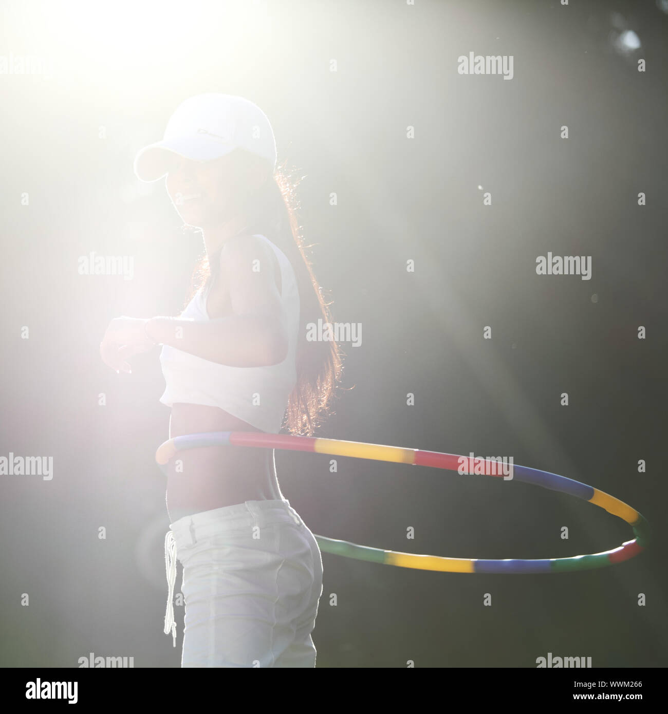 woman rotates hula hoop on nature background Stock Photo - Alamy