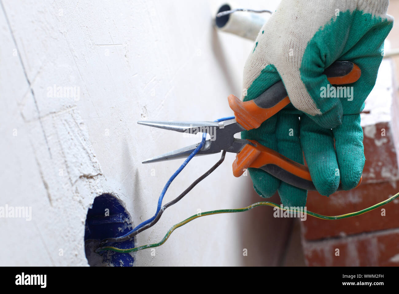 worker puts the wires in the wall Stock Photo Alamy