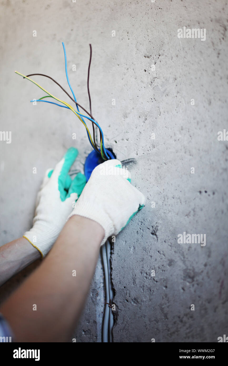 worker puts the wires in the wall Stock Photo Alamy
