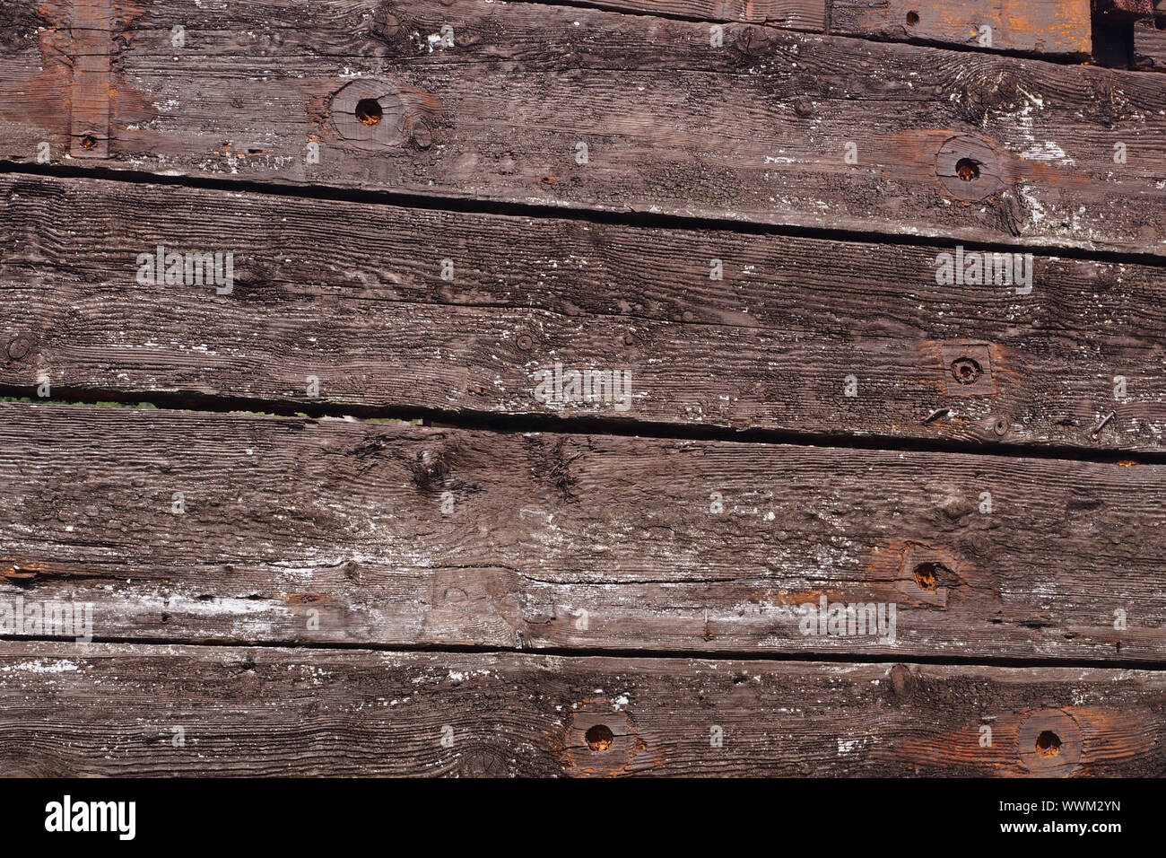 A close up view of reclaimed timber reused to build a timber barn showing the old bolt holes, the grain and thickness and quality of the timber boards Stock Photo