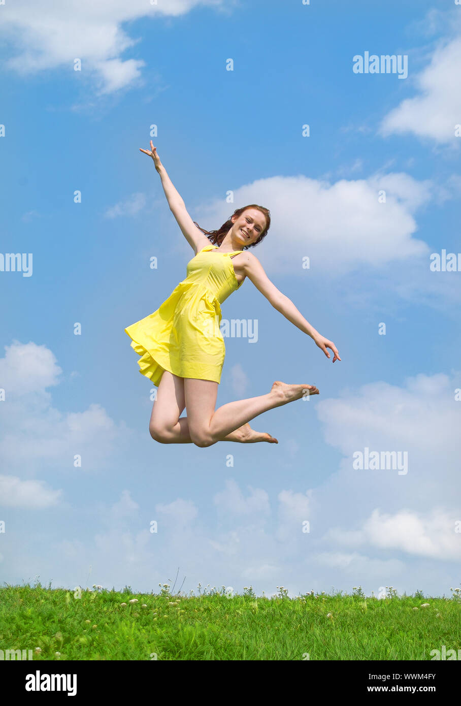 Beautiful lady in yellow dress and hat jumping Stock Photo - Alamy
