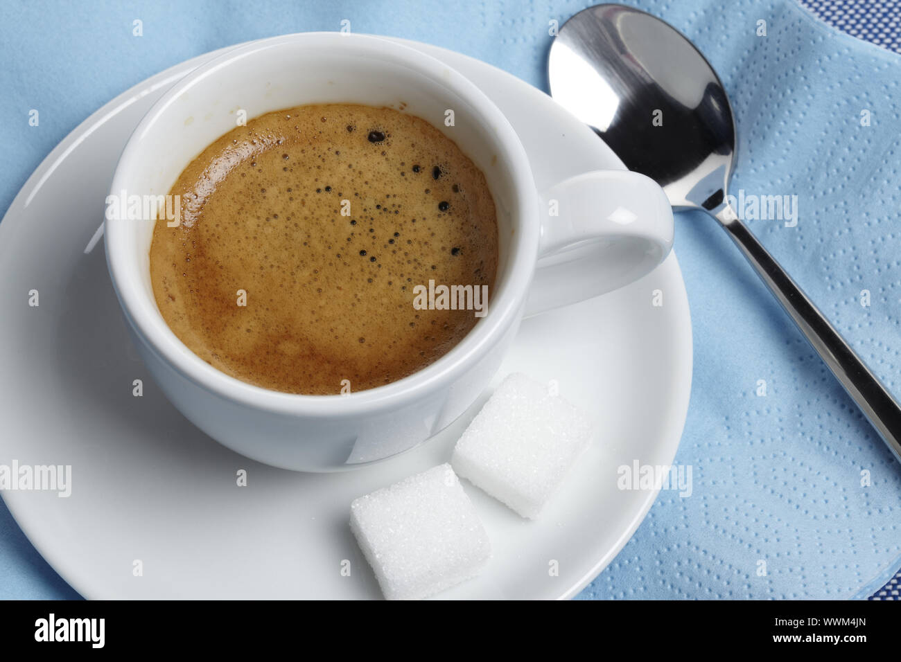 Espresso with sugar cubes and spoon on napkin Stock Photo - Alamy