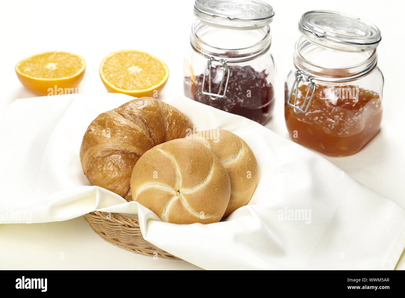 Basket with bread rolls and jam Stock Photo - Alamy