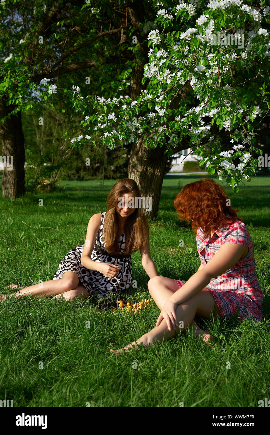 Young girls playing chess on the grass Stock Photo