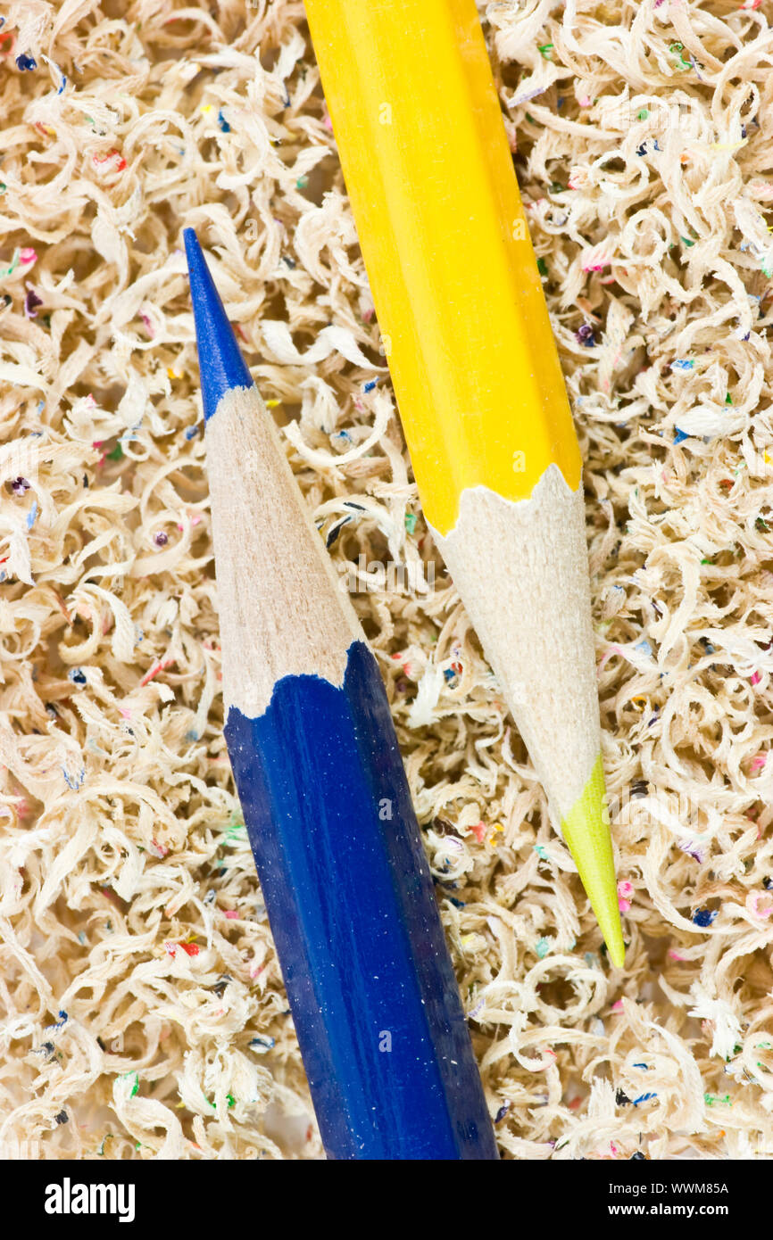 Blue and yellow wooden pencils in pencil shaving Stock Photo Alamy