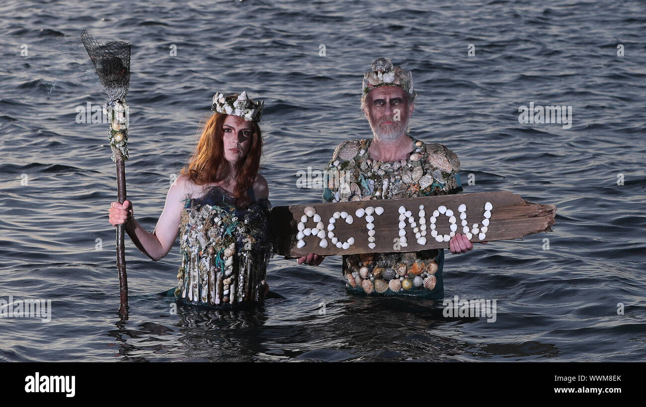 Ceara Carney,and Louis Heath, of Extinction Rebellion Ireland, dressed as â€˜sea godsâ€™, at Killiney Bay Dublin, as activists have demanded the Irish Government turn the tide on its bid to tackle climate change. Stock Photo