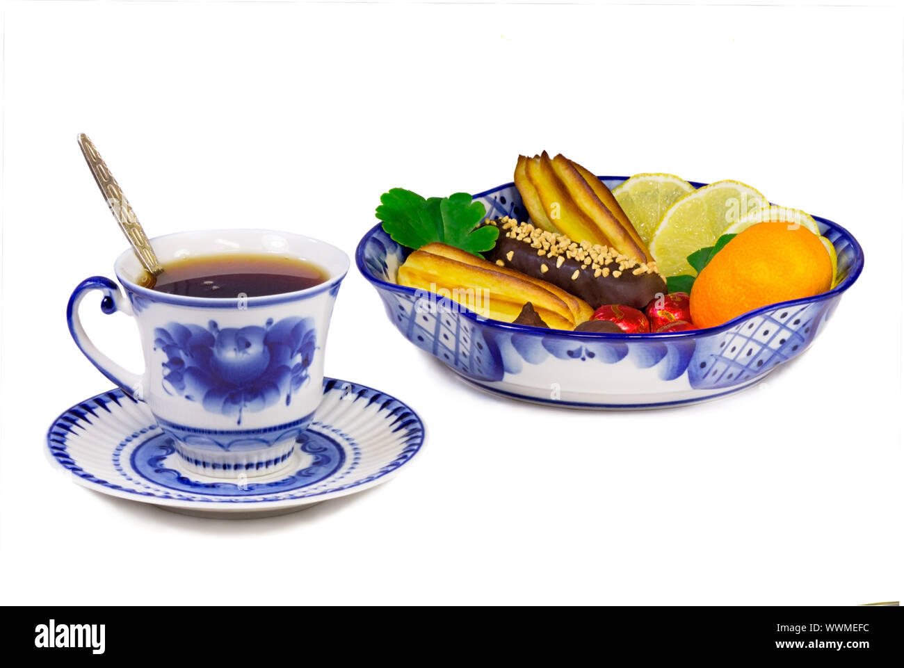 Cup of tea, cakes, sweets, fruit bowl, painted in the style of the Gzhel Stock Photo